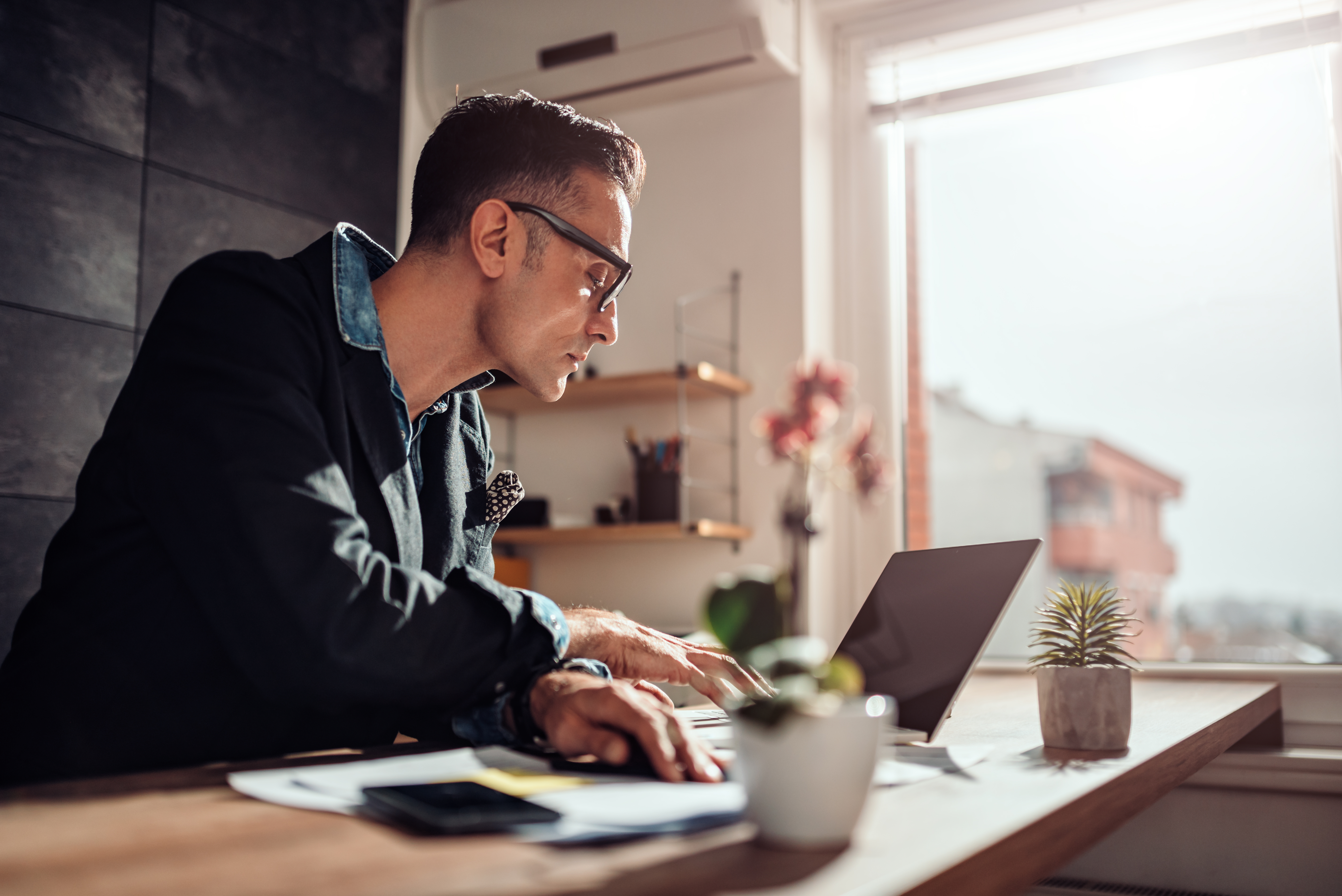 Businessman sitting at his desk and using laptop in the office